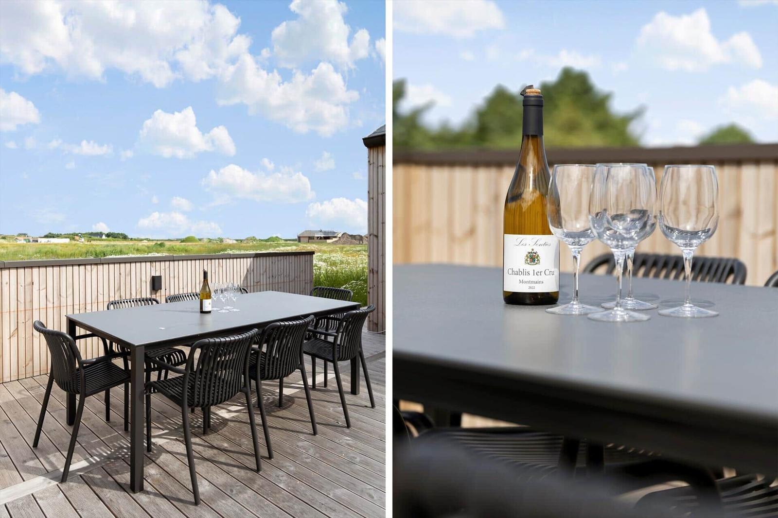 Terrasse mit Tisch und Stühlen. Flasche Chablis 1er Cru und Gläser.