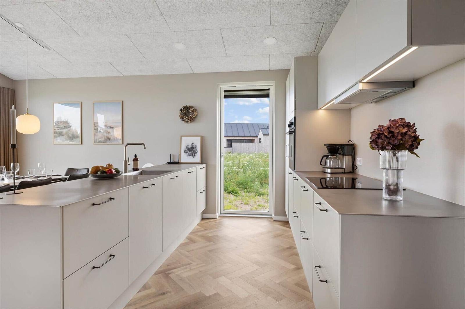 Moderne Küche mit Kücheninsel, Holzboden und Blick auf Garten