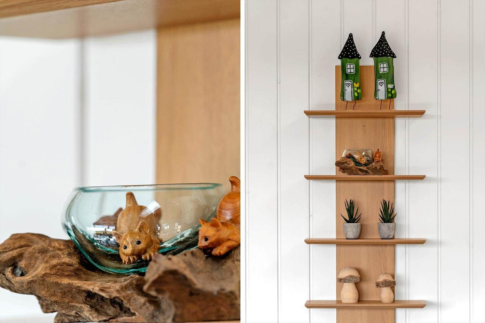 Holzregal mit Dekorationsgegenständen an weißer Wand