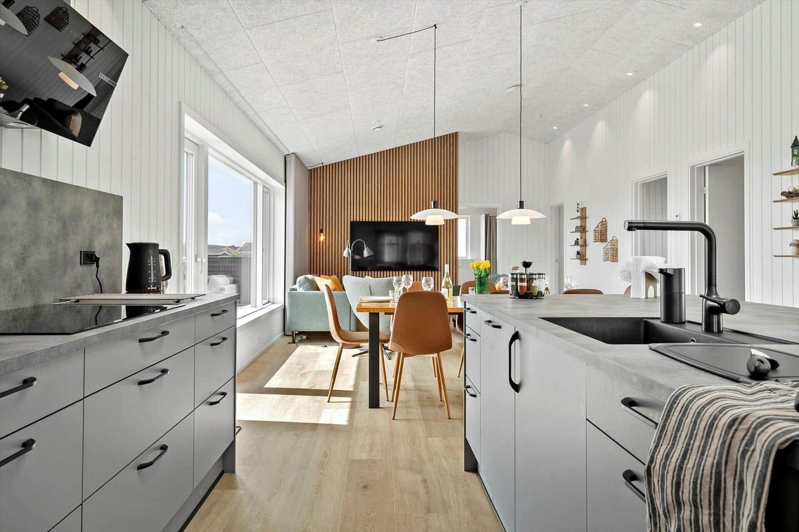 Küche mit Essbereich und Wohnzimmer im Hintergrund.