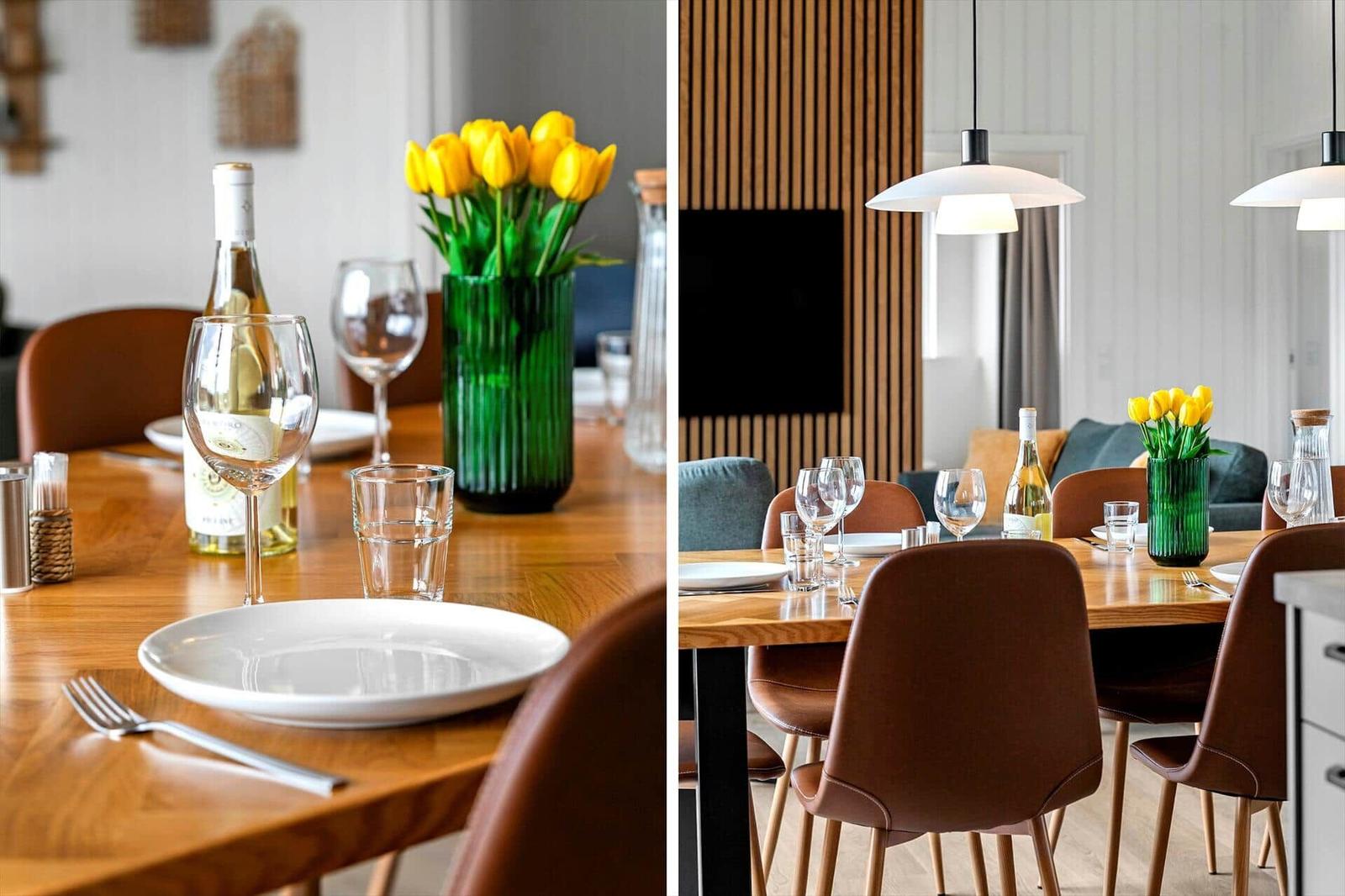 Holztisch mit Stühlen, Blumen und Flasche. Hintergrund mit Wandverkleidung und Lampe.