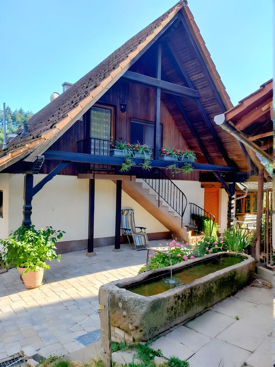 Haus mit Balkon, Treppenhaus und Brunnen im Garten