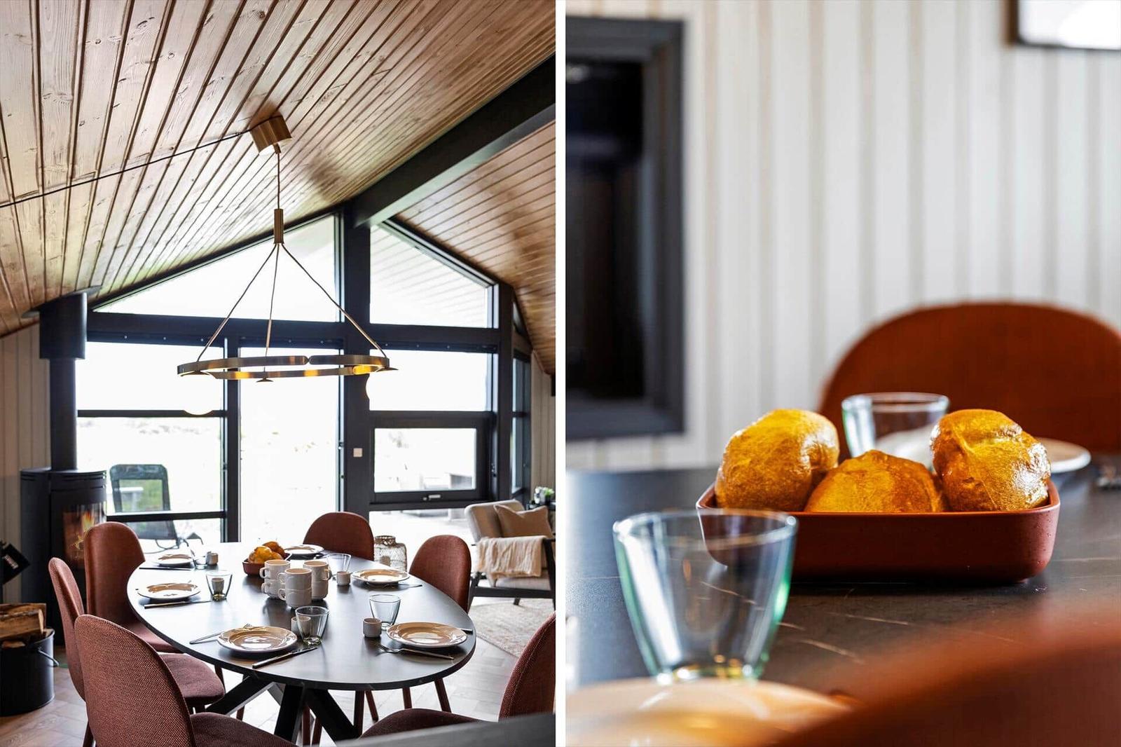 Esszimmer mit Holzdecke und großem Fenster. Tisch mit Tellern und Brot.