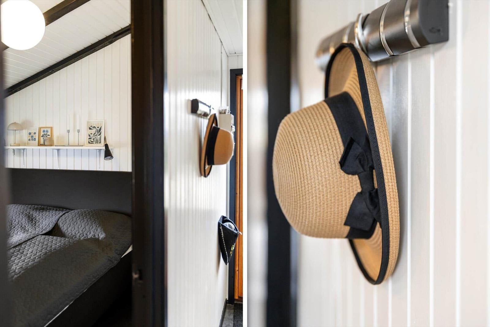 Schlafzimmer mit Bett und Wandregal. Hut hängt an Wandhalterung.