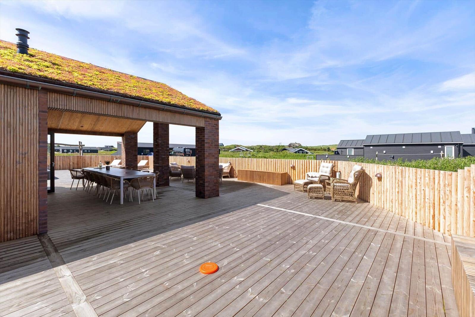 Terrasse mit Holzdecke, Sitzgruppe und Tisch unter Dach