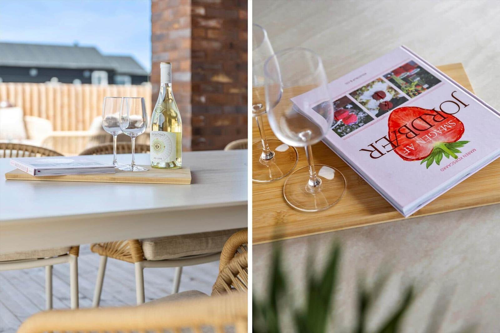 Tisch mit Wein, Gläsern und Buch auf Terrasse