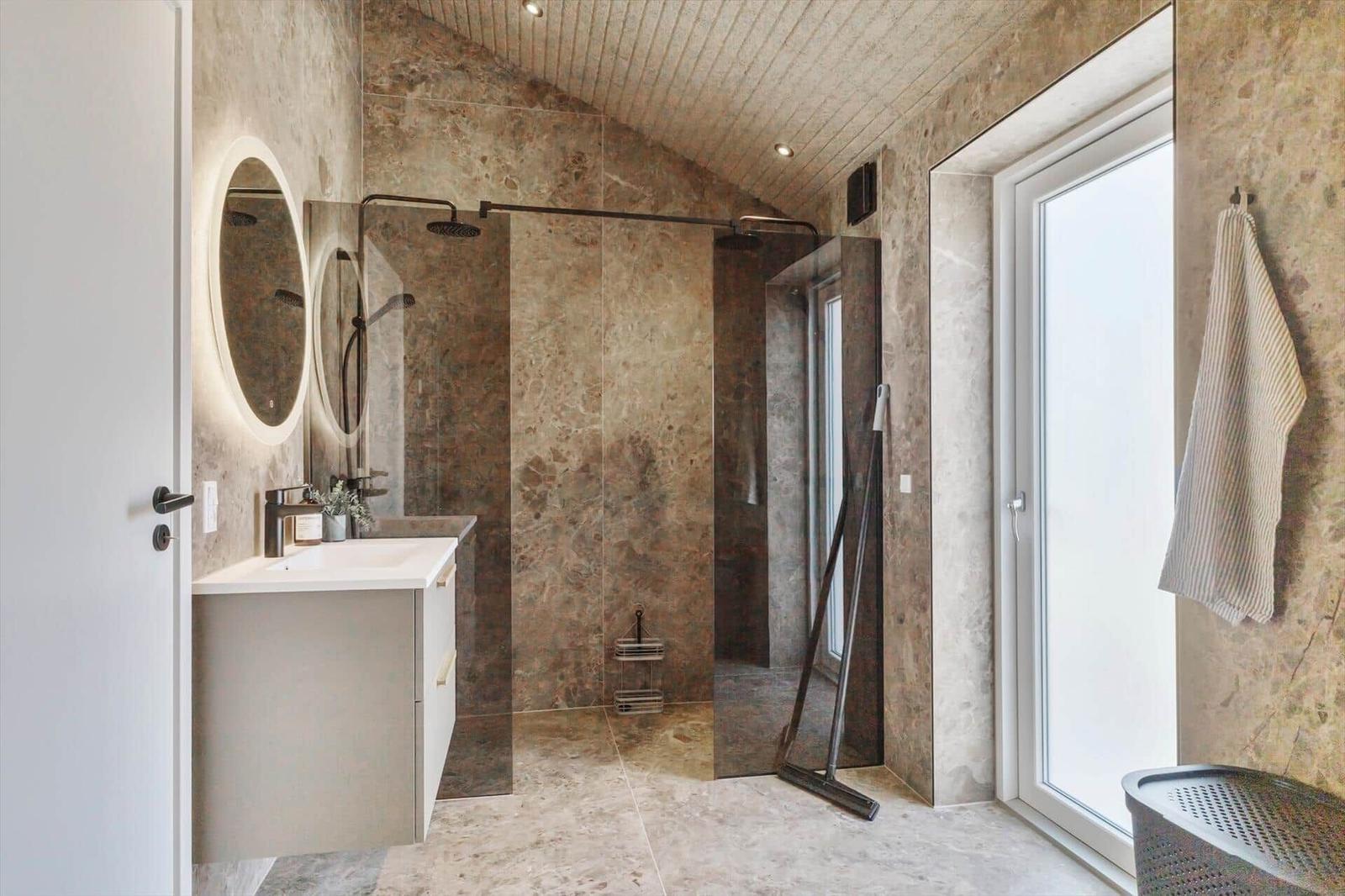Badezimmer mit Dusche, Waschbecken und Fenster