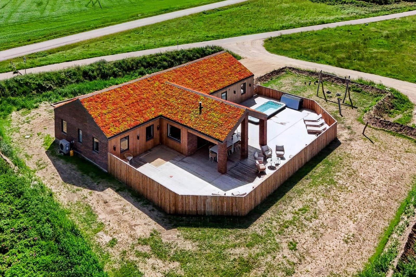 Haus mit grüner Dachdeckung, Pool und Terrasse im Grünen
