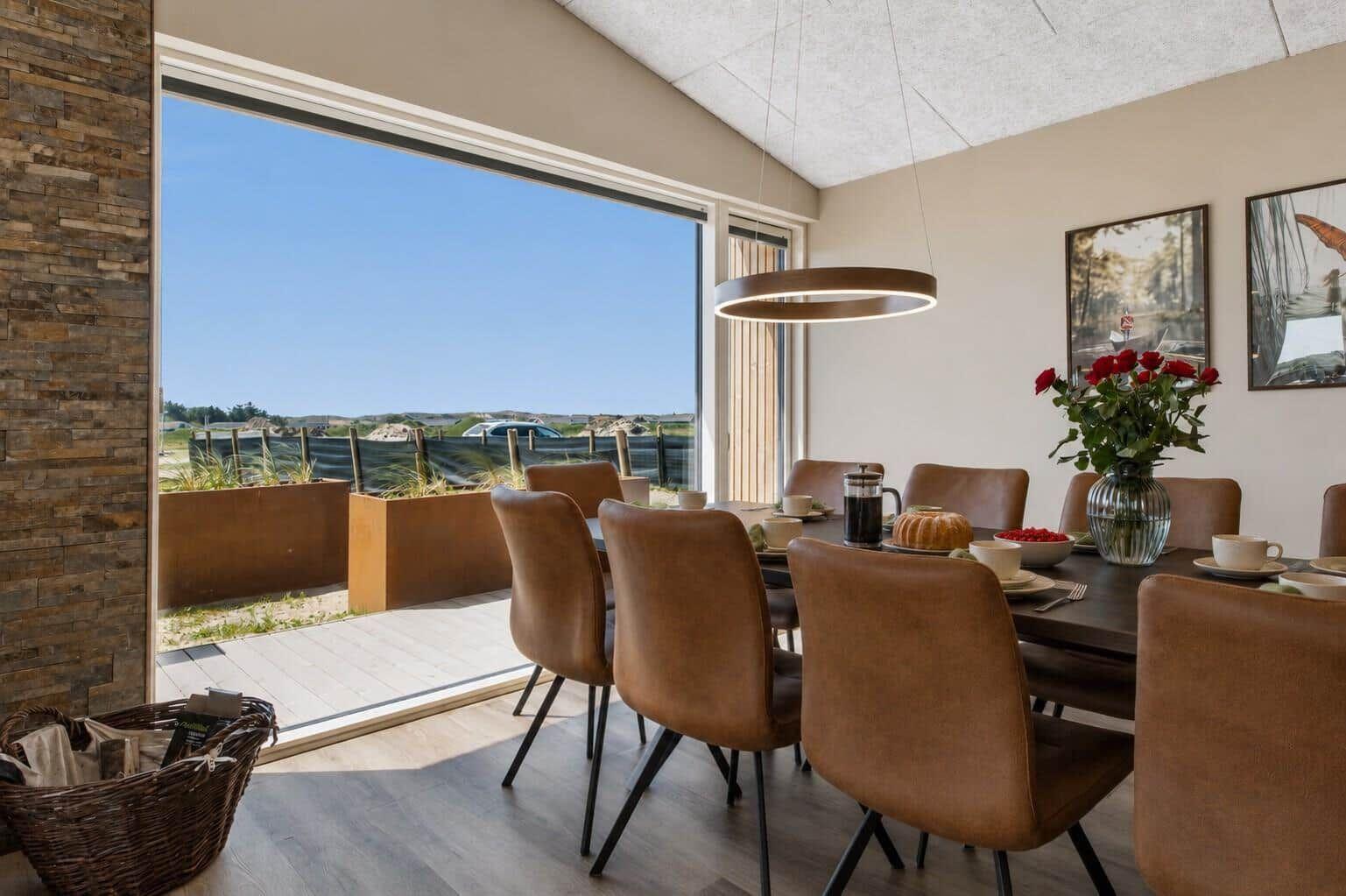 Esszimmer mit Sicht auf den Strand und Terrasse mit Pflanzenkästen.