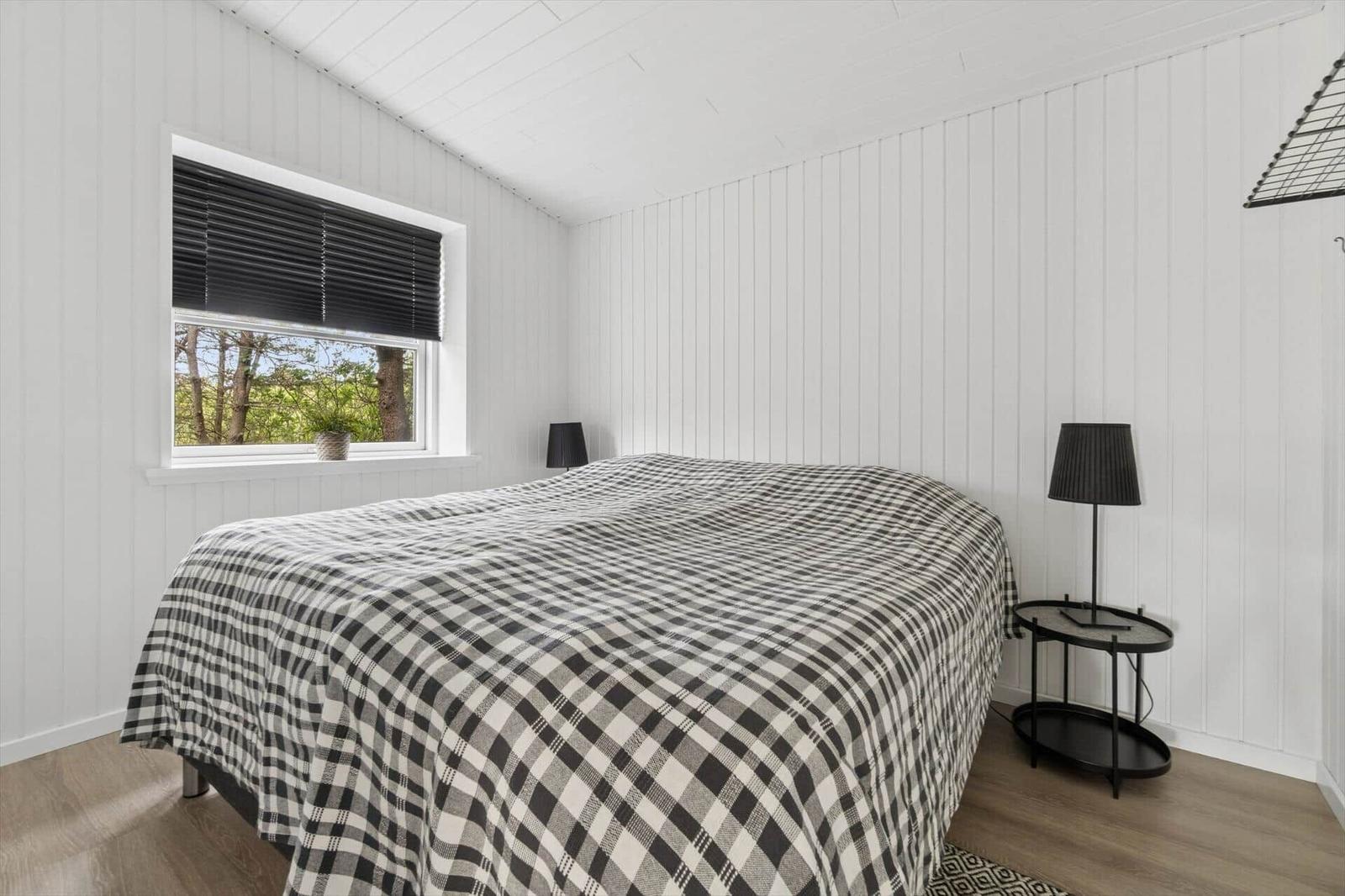 Schlafzimmer mit Bett, Fenster und Nachttisch