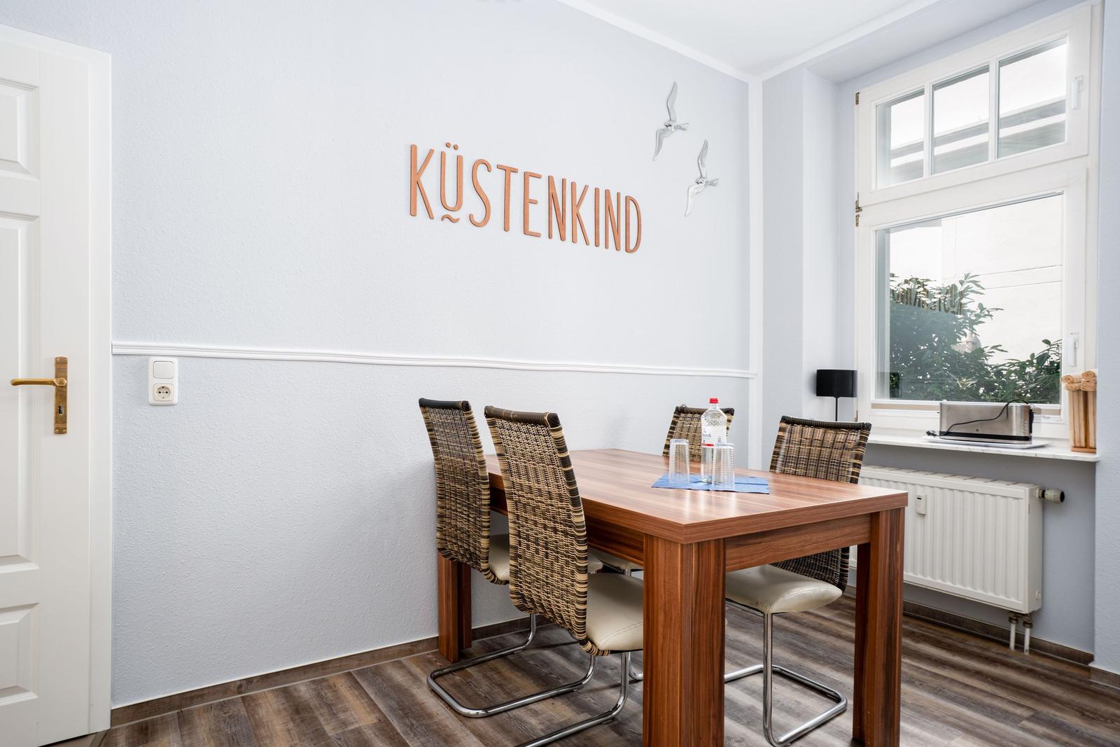 Dining room with table, chairs, and wall decor Küstenkind.