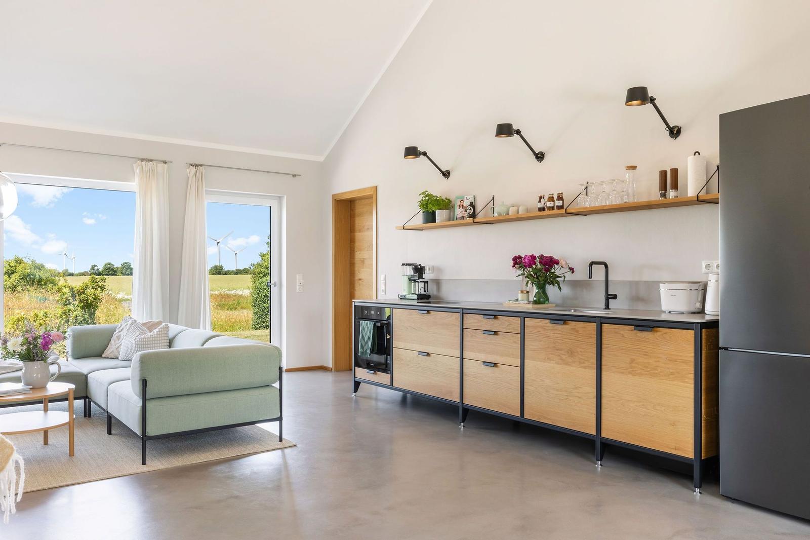 Küche mit Holzschränken und Blick auf Felder