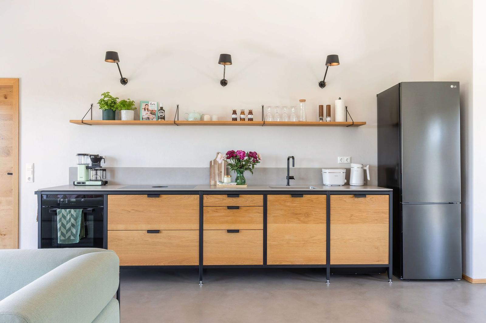 Moderne Küche mit Holzschränken, Edelstahlkühlschrank und Küchenzeile.