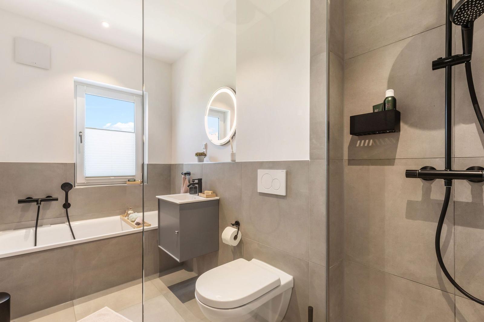 Badezimmer mit Dusche, Badewanne, Toilette und Waschbecken.