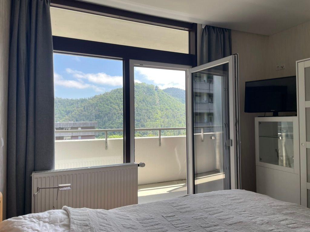 Schlafzimmer mit Balkon und Bergblick. TV und Schrank sind vorhanden.