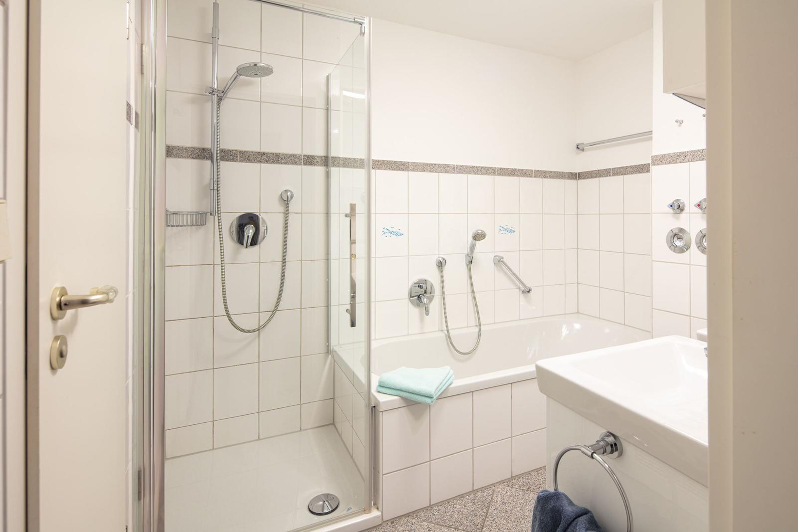 Badezimmer mit Dusche, Badewanne und Waschbecken.