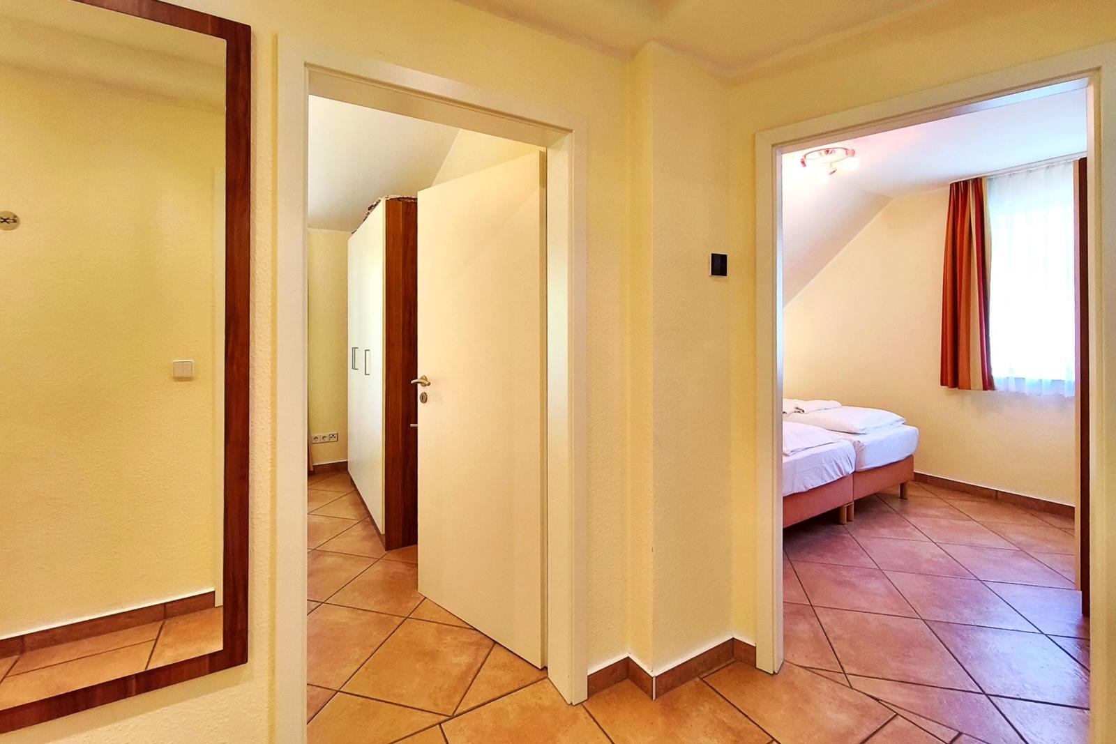 Heller Flurbereich mit Blick in das angrenzende, zweite Schlafzimmer