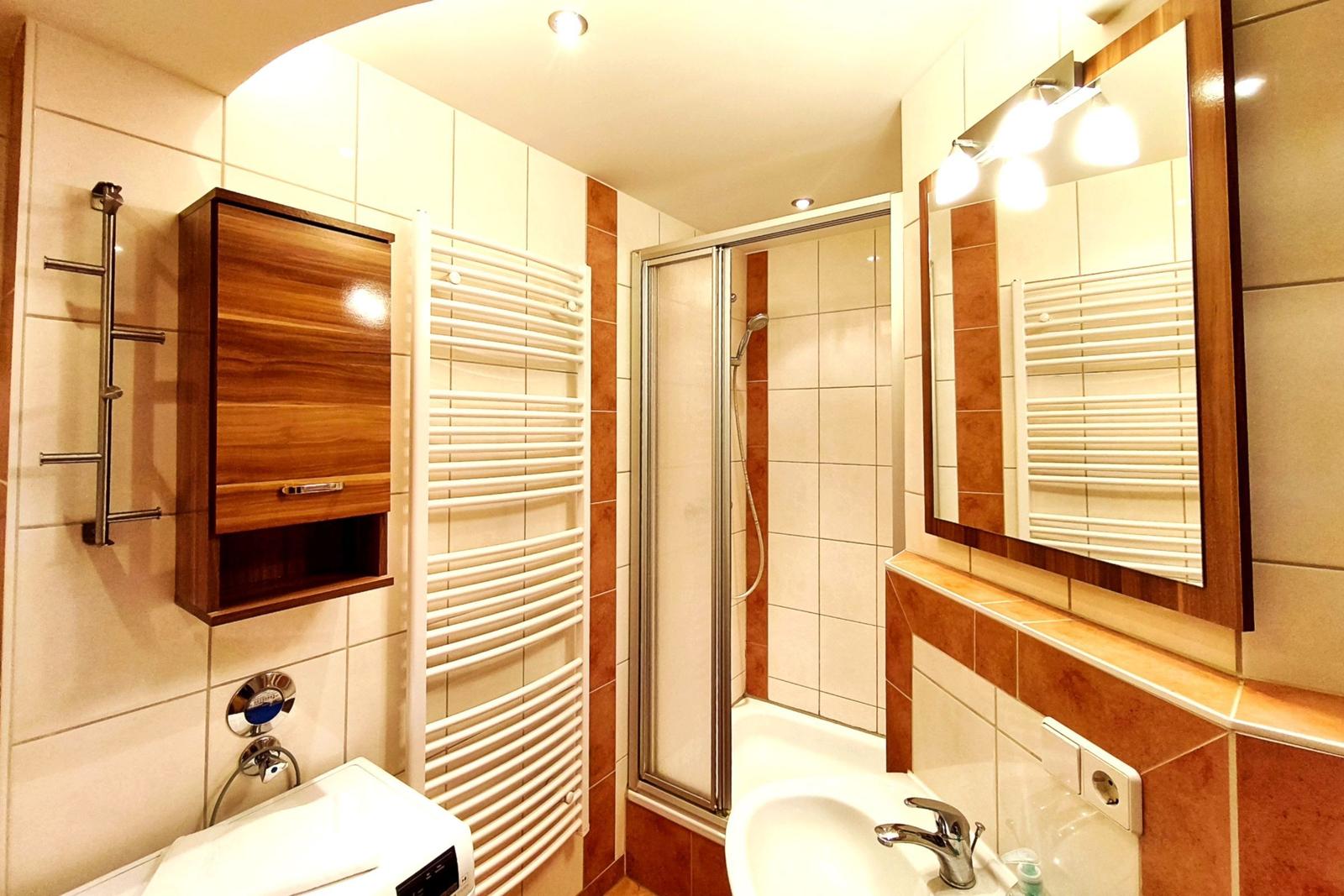 Modernes Badezimmer mit Waschtisch und großem Spiegel in Koserow