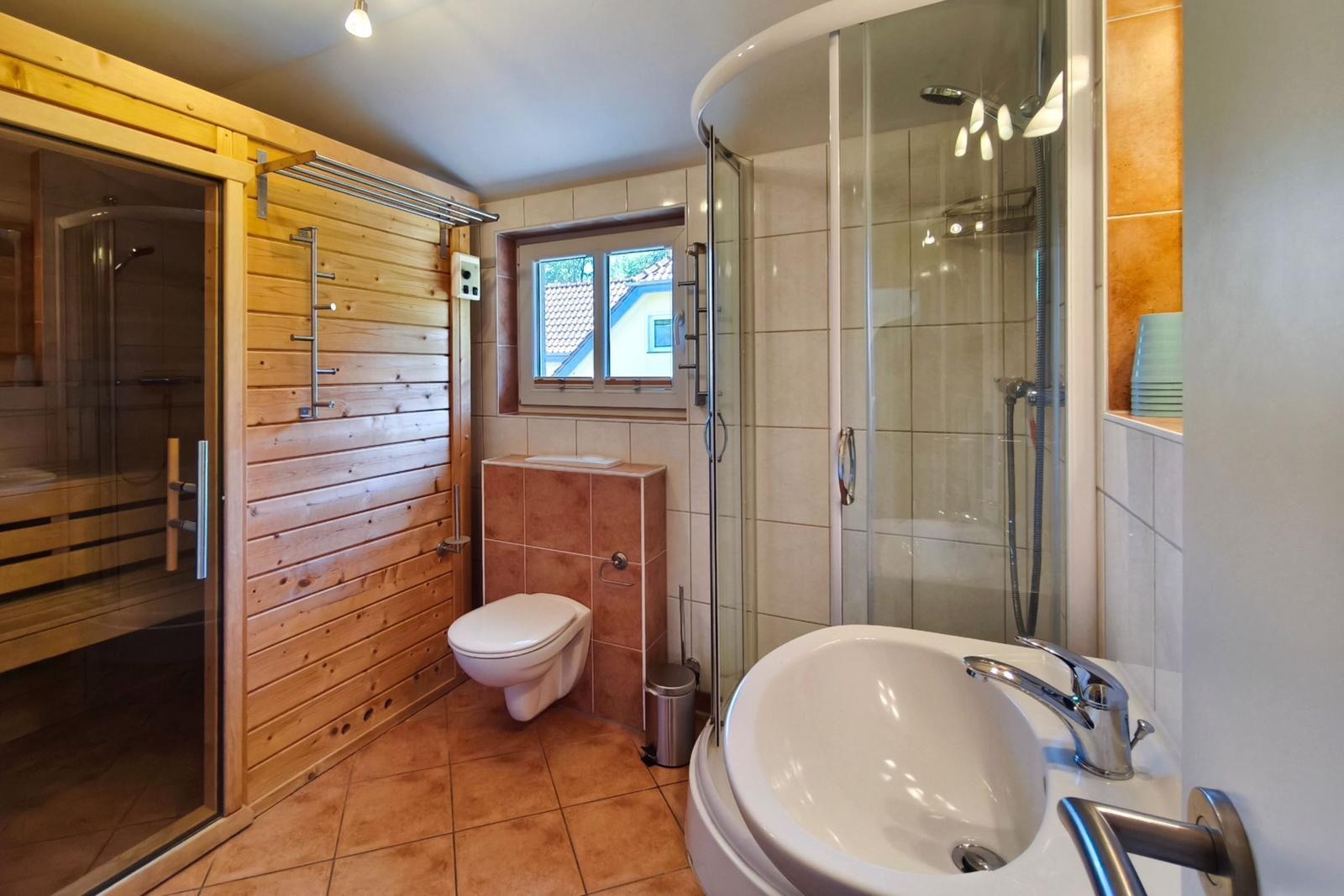 Hauptbadezimmer mit Waschtisch, Dusche und integriertem Zugang zum Wellnessbereich