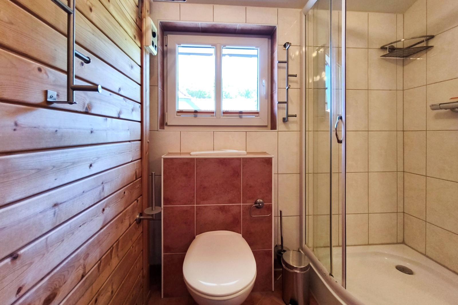 Gepflegtes Badezimmer mit Toilette, Waschbecken und Dusche