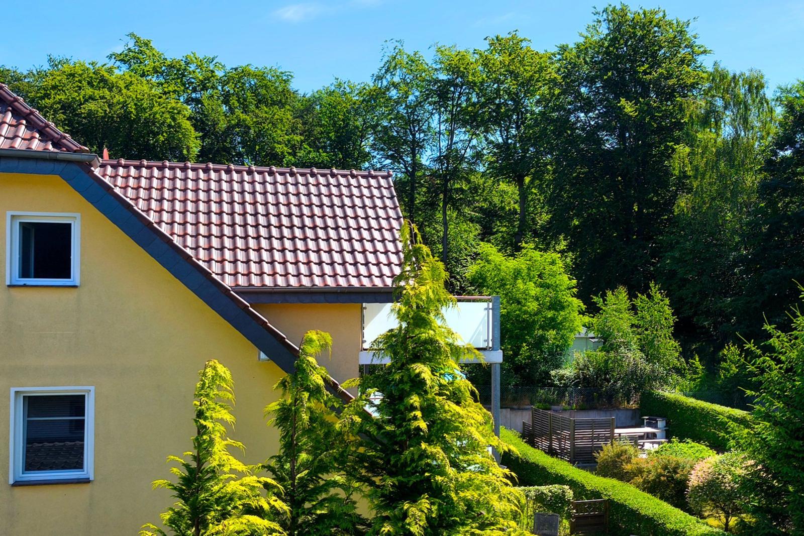 Idyllisches Gartengrundstück mit dichten Baumkronen rund um das Urlaubsdomizil