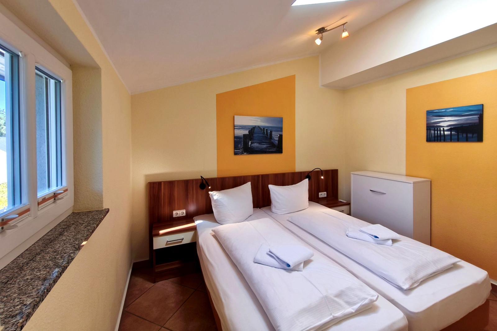 Erstes Schlafzimmer mit komfortablem Doppelbett unter hellem Dachfenster