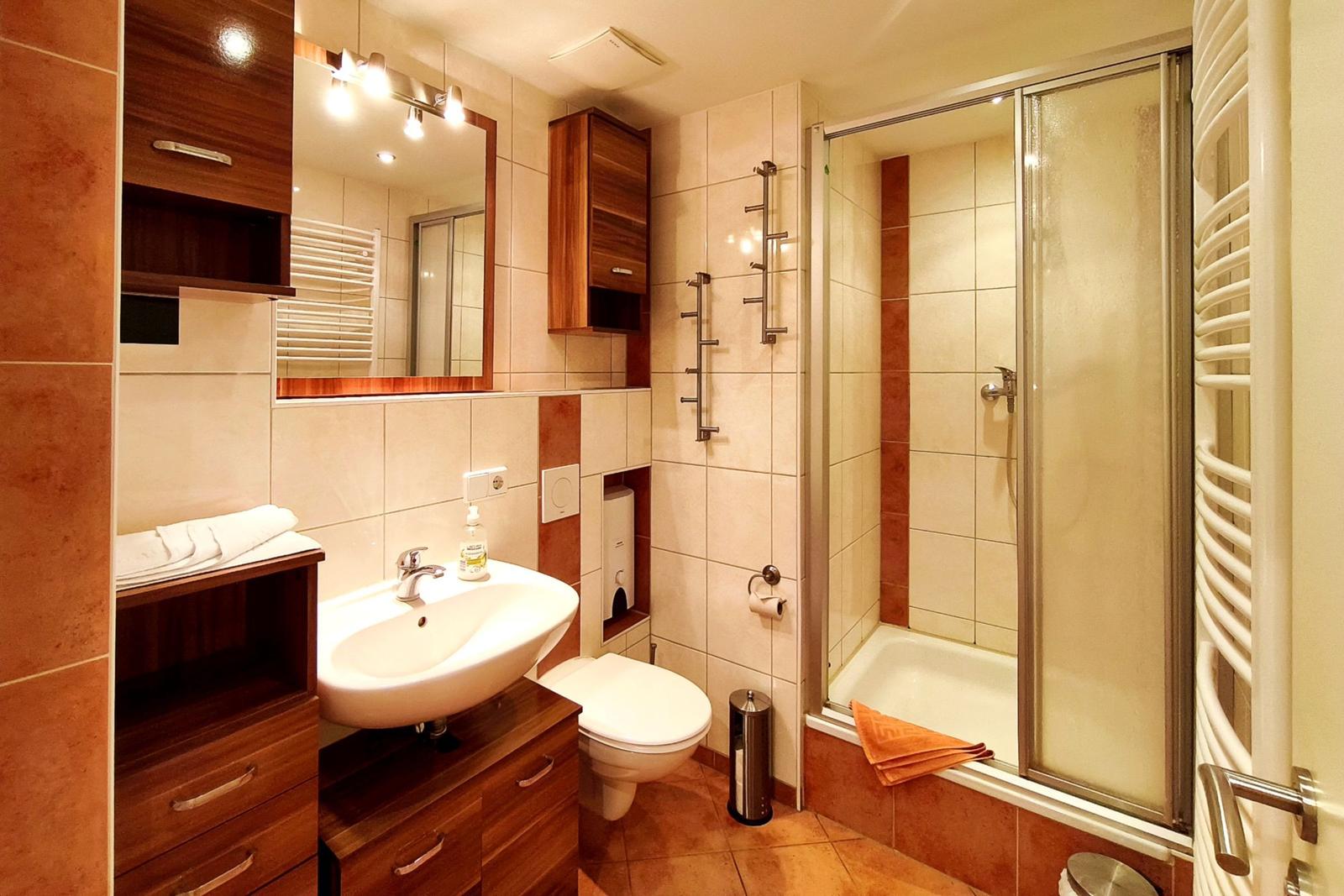 Modernes Badezimmer mit Glasedelstahl-Dusche und hellem Waschtisch