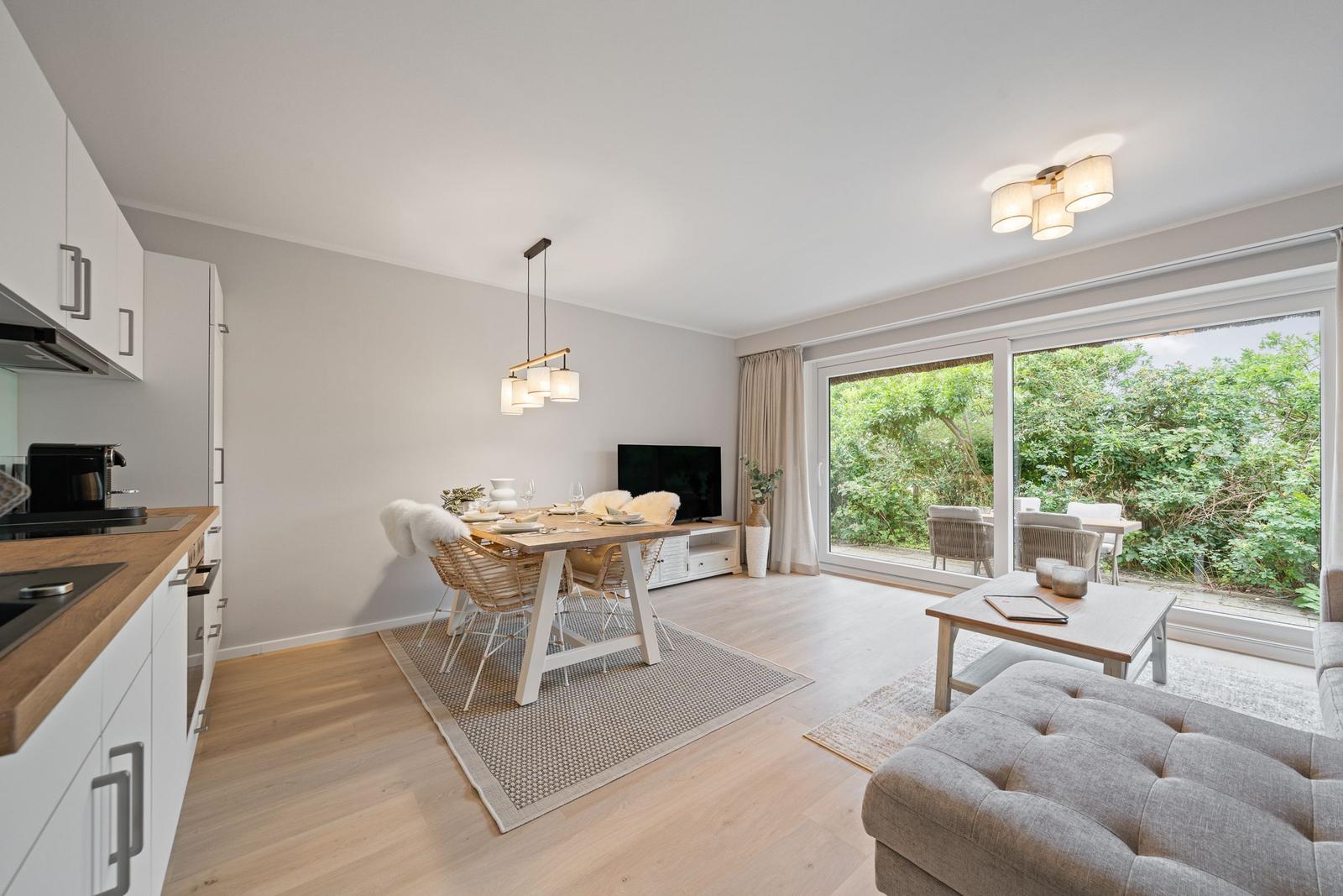 Wohn- und Essbereich mit Küchenzeile, Terrasse und Gartenansicht.