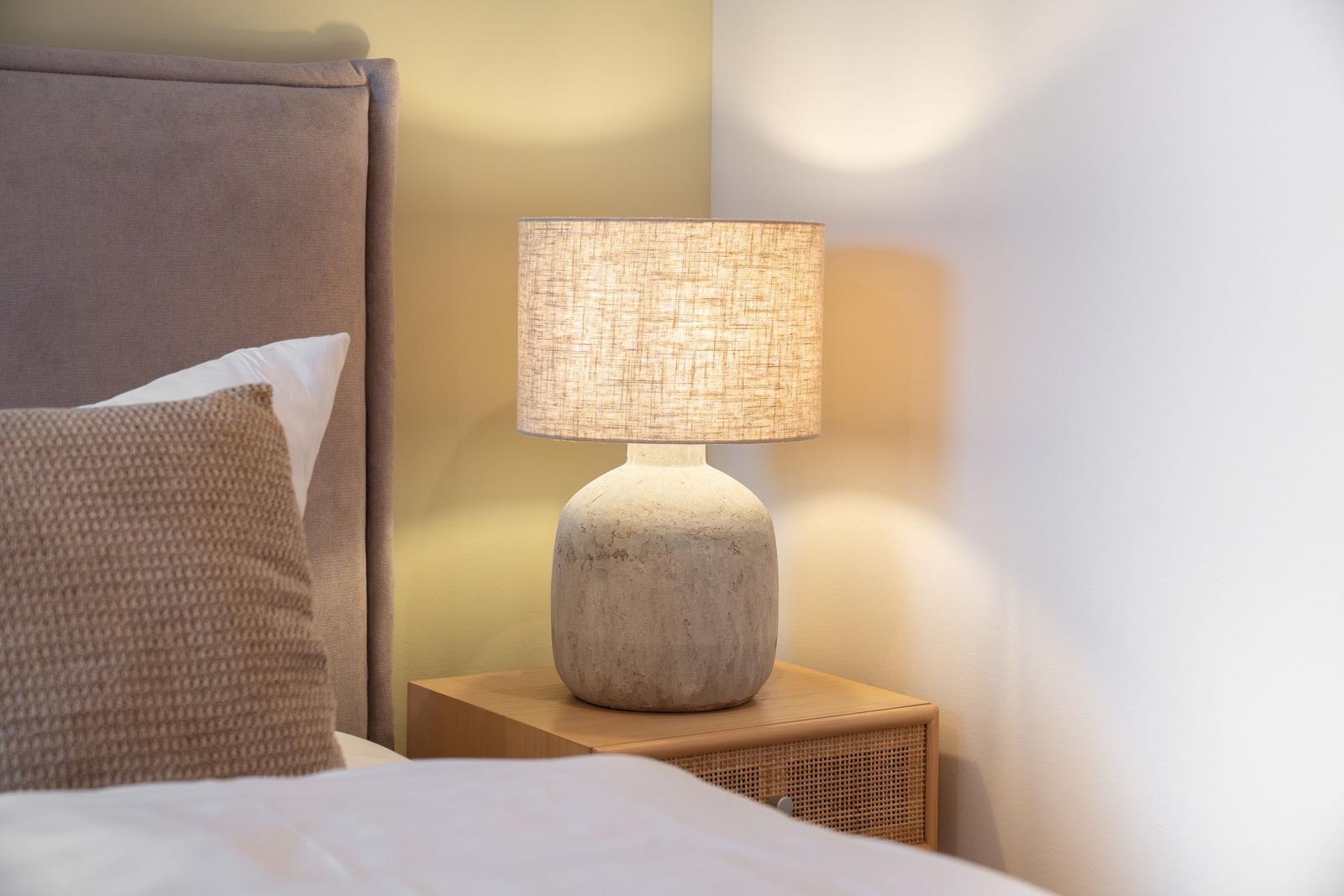 Bettkopfteil, Kissen und Nachttisch mit Lampe