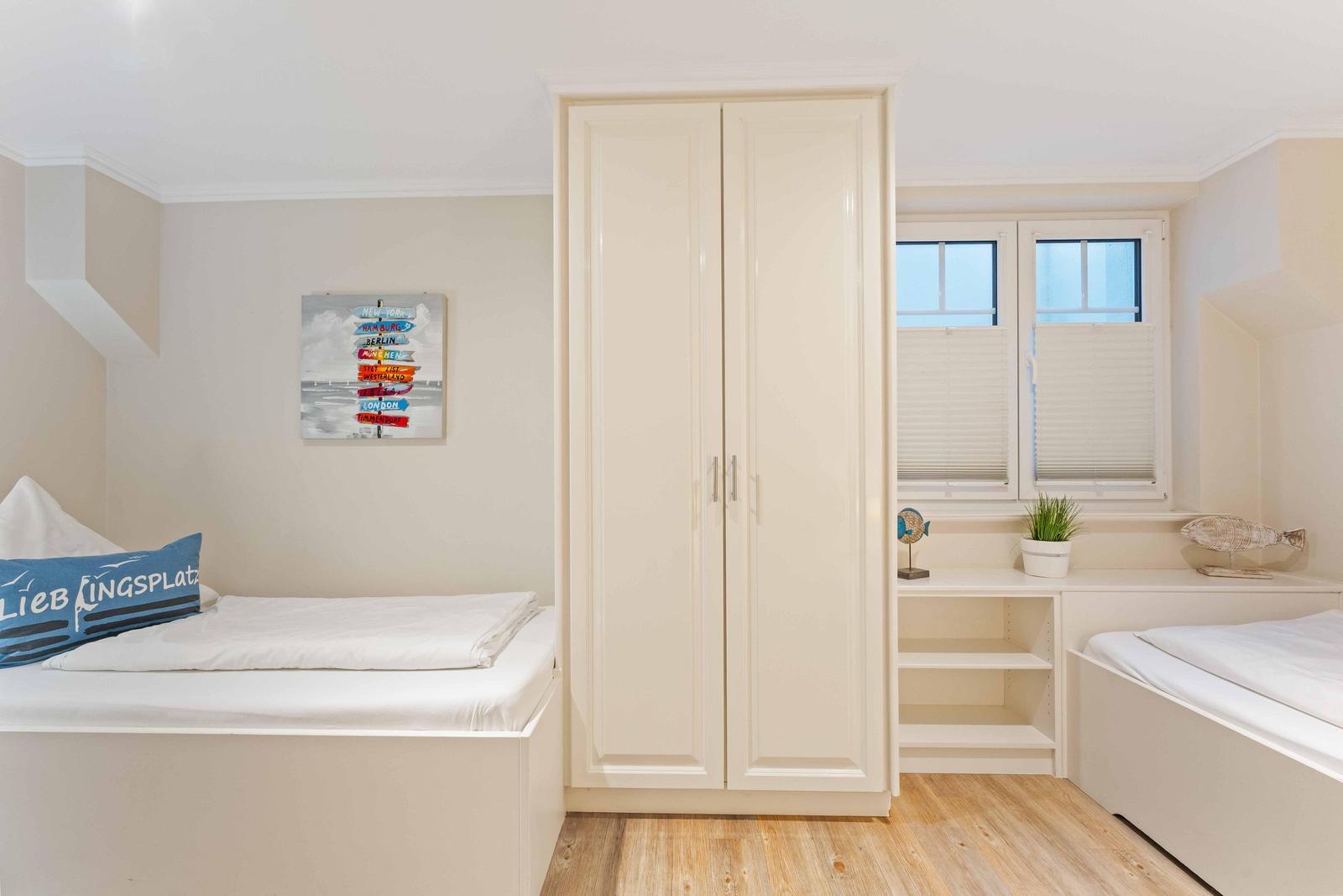 Zimmer mit zwei Einzelbetten, Schwebetüren und Fenster mit Jalousien.