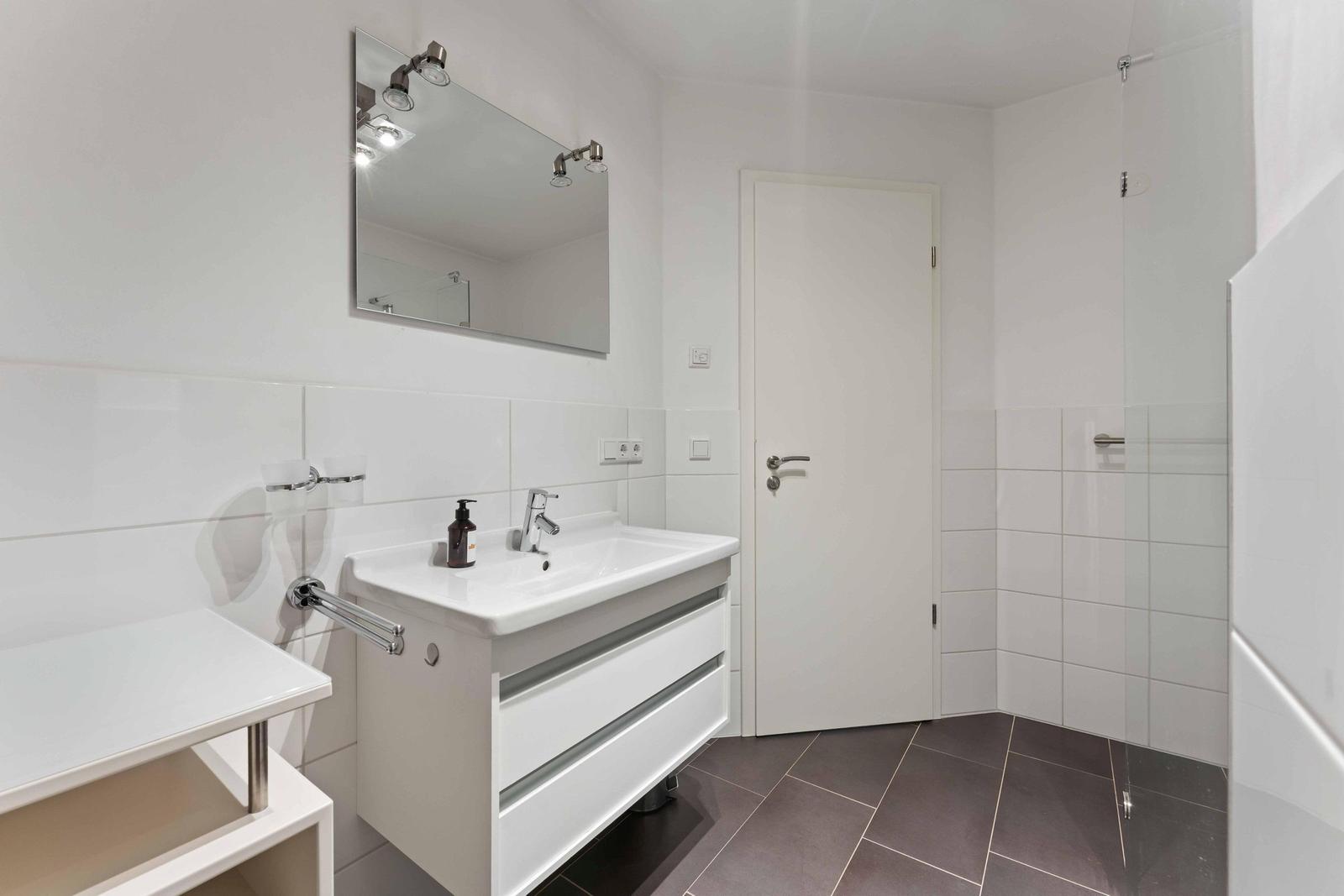 Bathroom with sink, mirror, and shower.