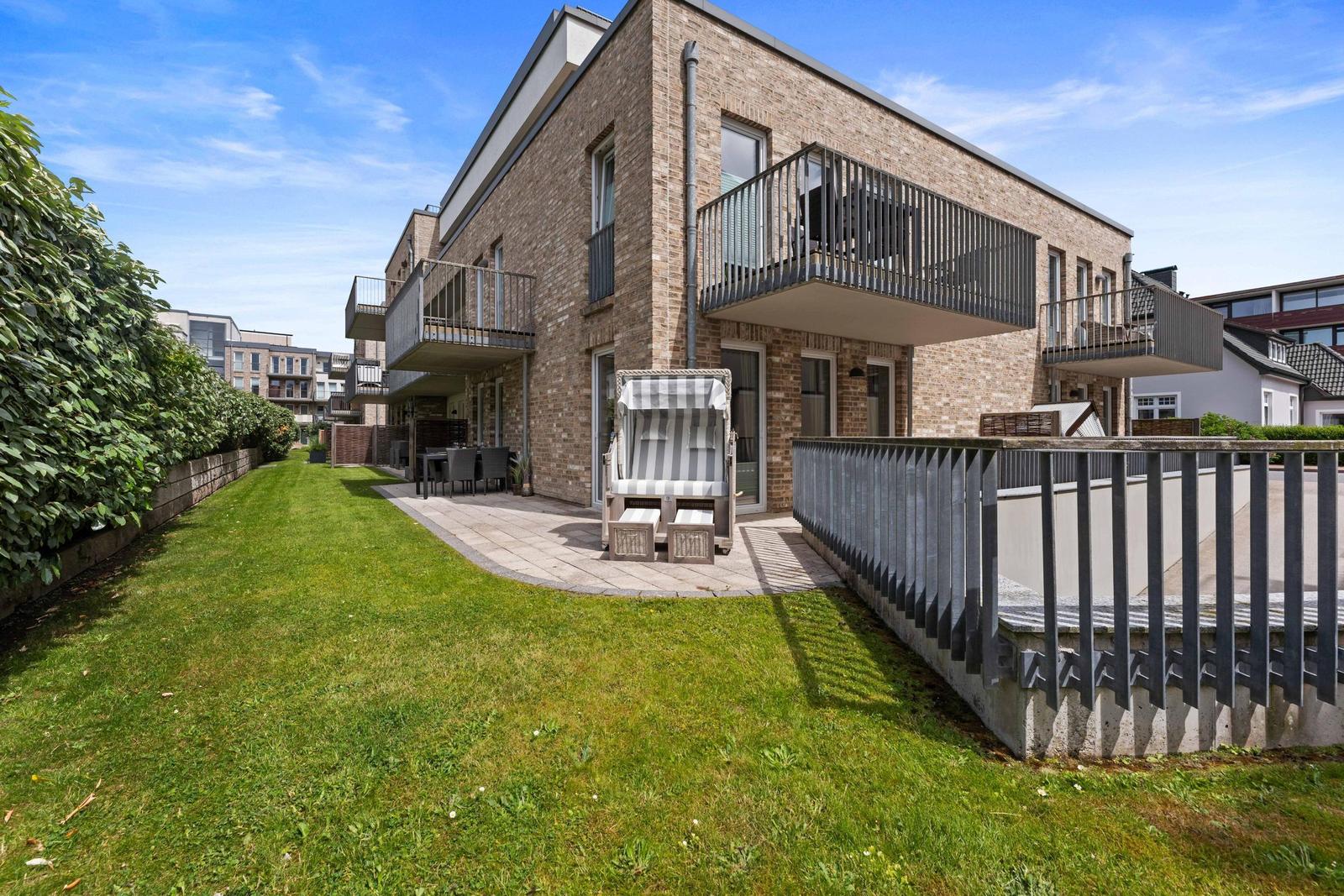 Modern house with balcony, garden, and lounge chair. Ideal for vacation.