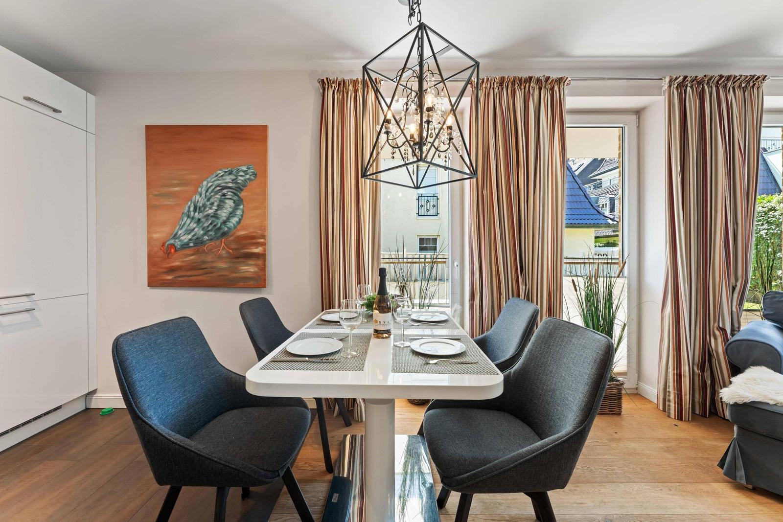 Dining room with table, chairs, and view of balcony