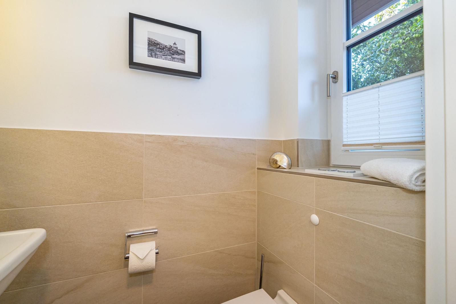 Badezimmer mit Fenster, Toilette und Wandbild