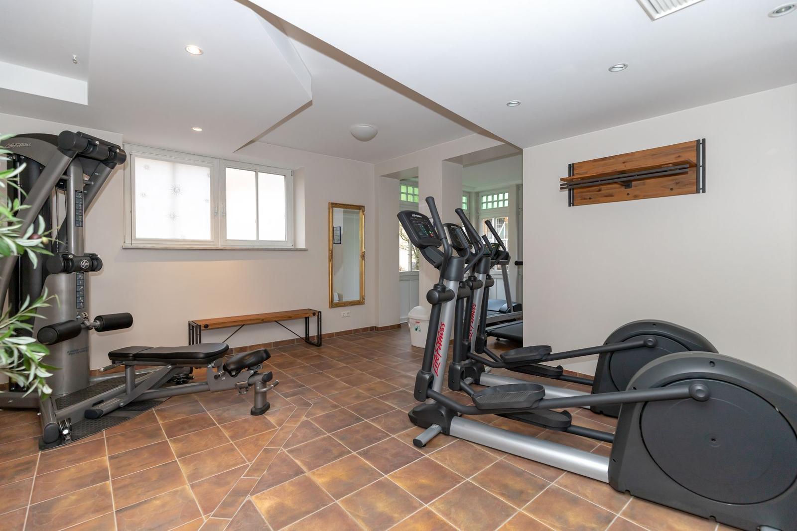 Fitnessraum mit Laufbändern, Kabelmaschine und Bank