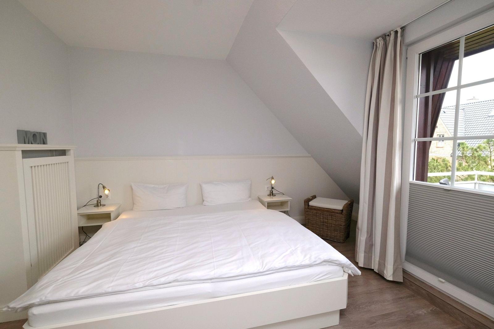 Schlafzimmer mit Doppelbett, Nachttischen und Fenster mit Blick.