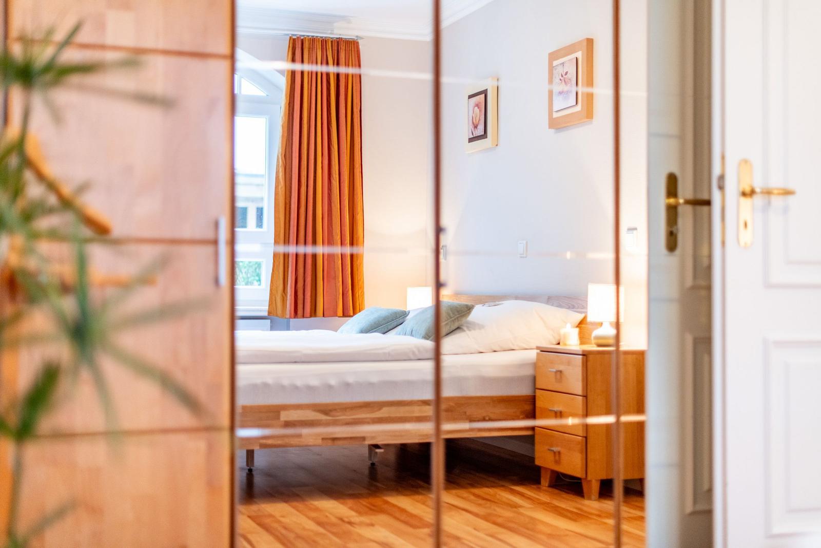 Schlafzimmer mit Bett, Nachttisch und Vorhang