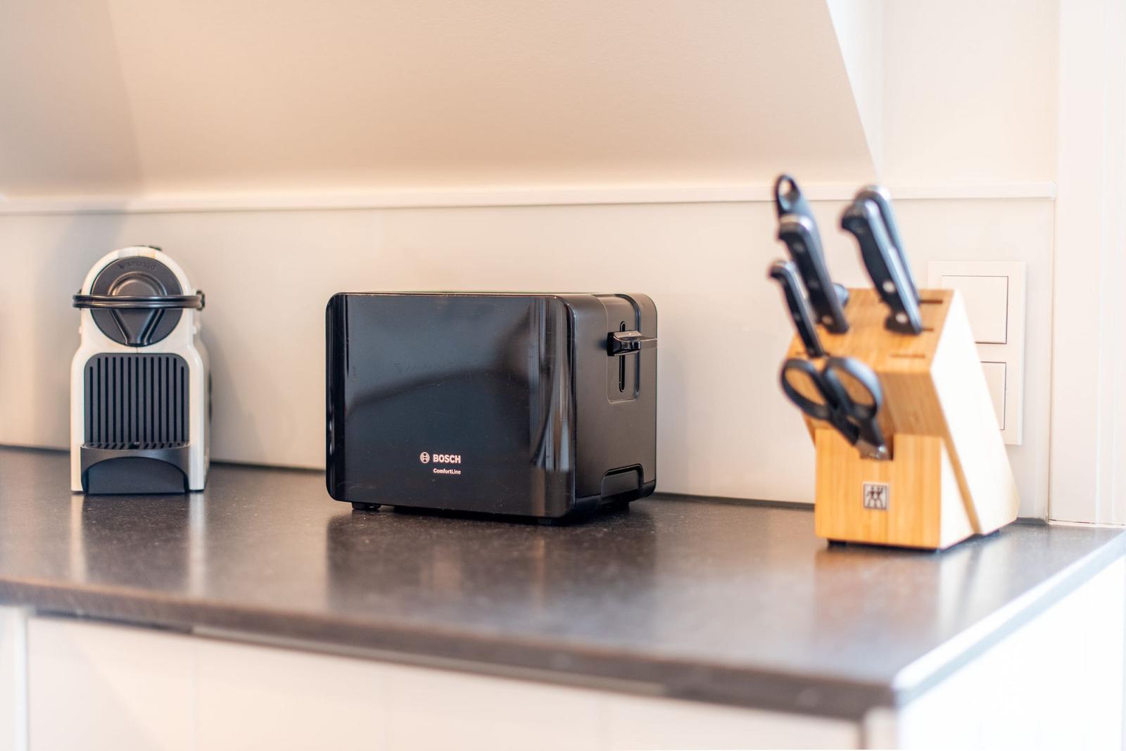 Küchenarbeitsplatte mit Toaster, Kaffeemaschine und Messerblock.