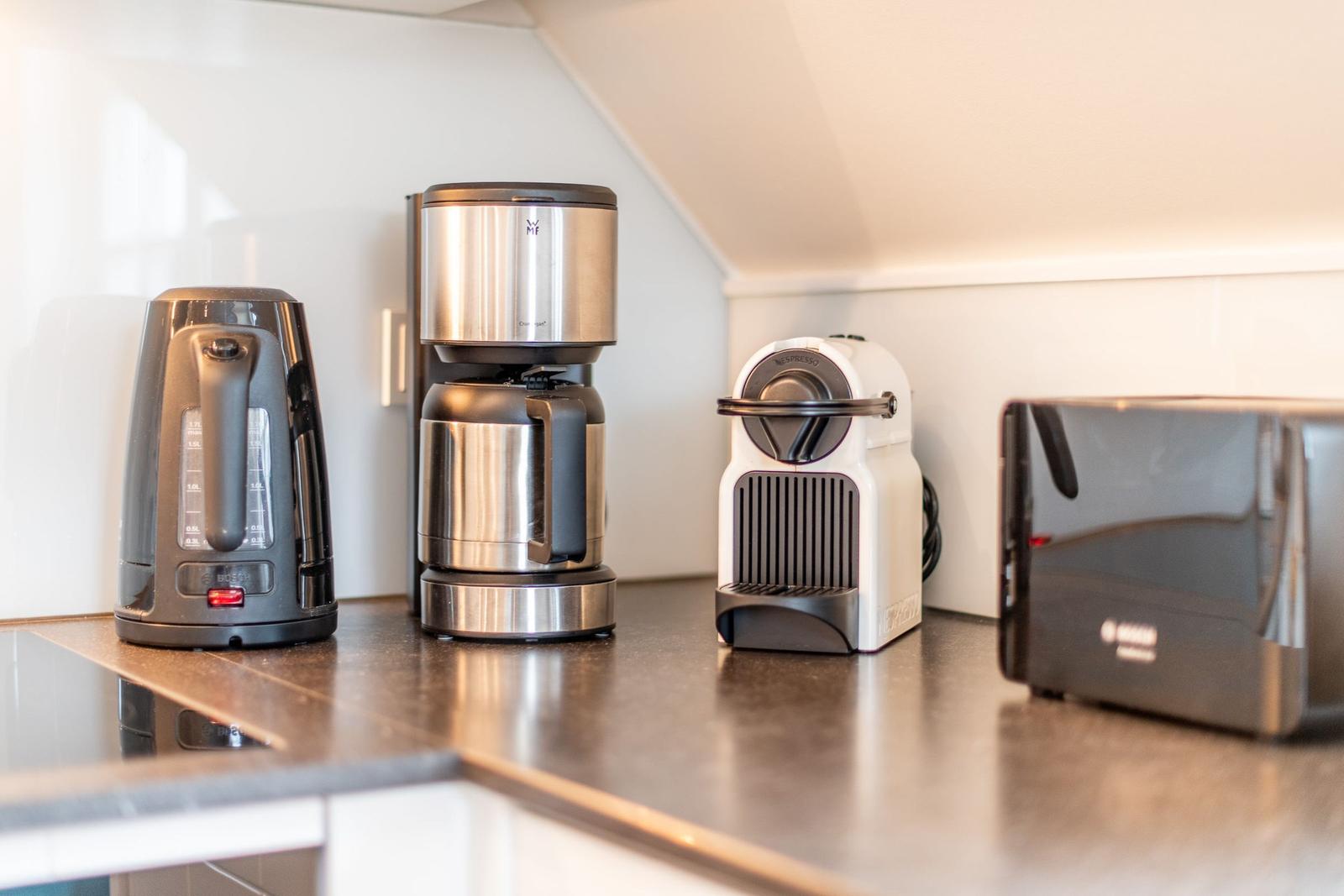 Küchenzeile mit Kaffeemaschine, Kaffeekanne und Toaster.