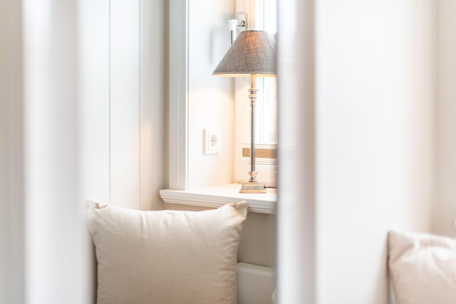 Ein Fensterbrett mit einer Lampe und einem Kissen.
