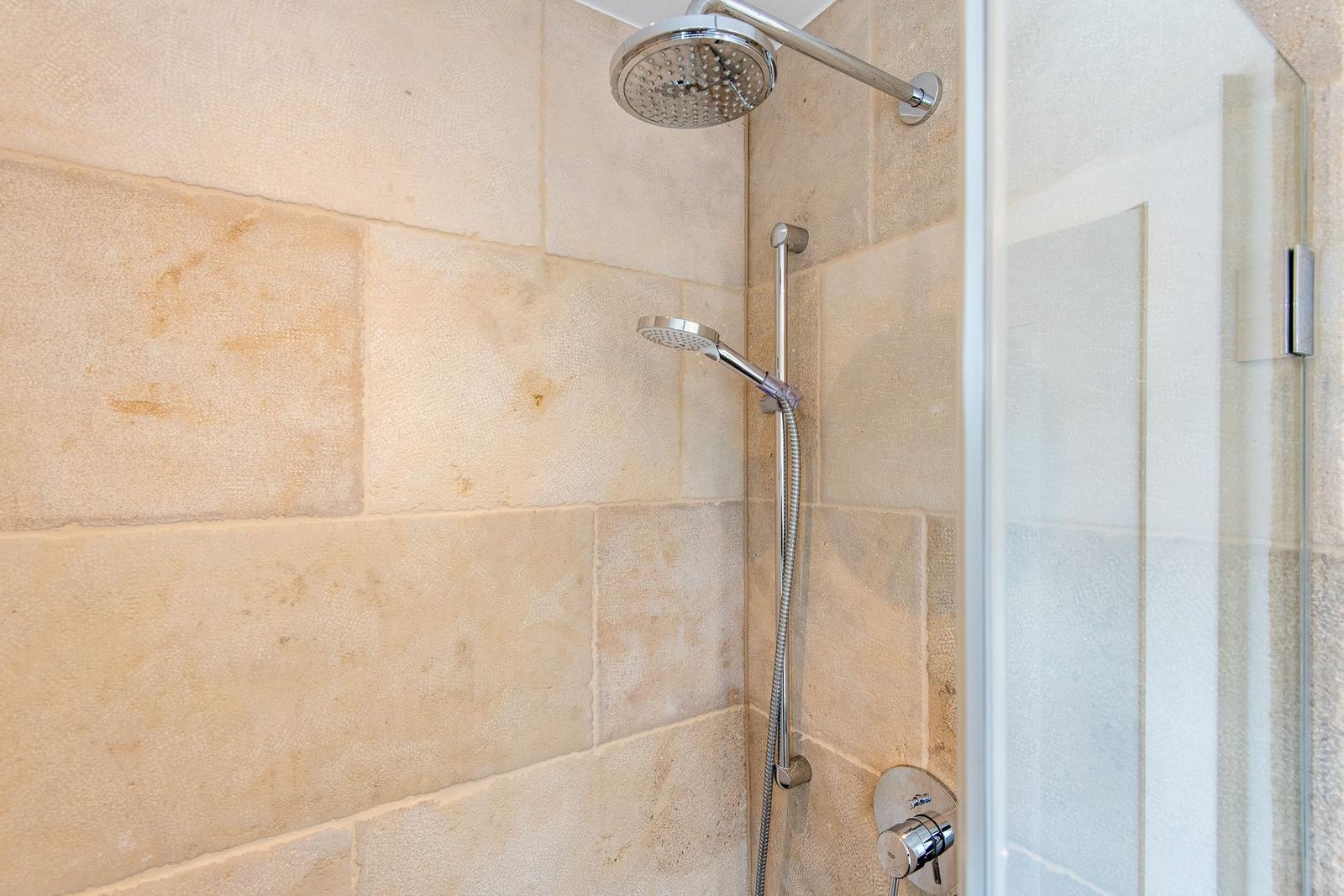 Dusche mit Steinwand und Duschbrause