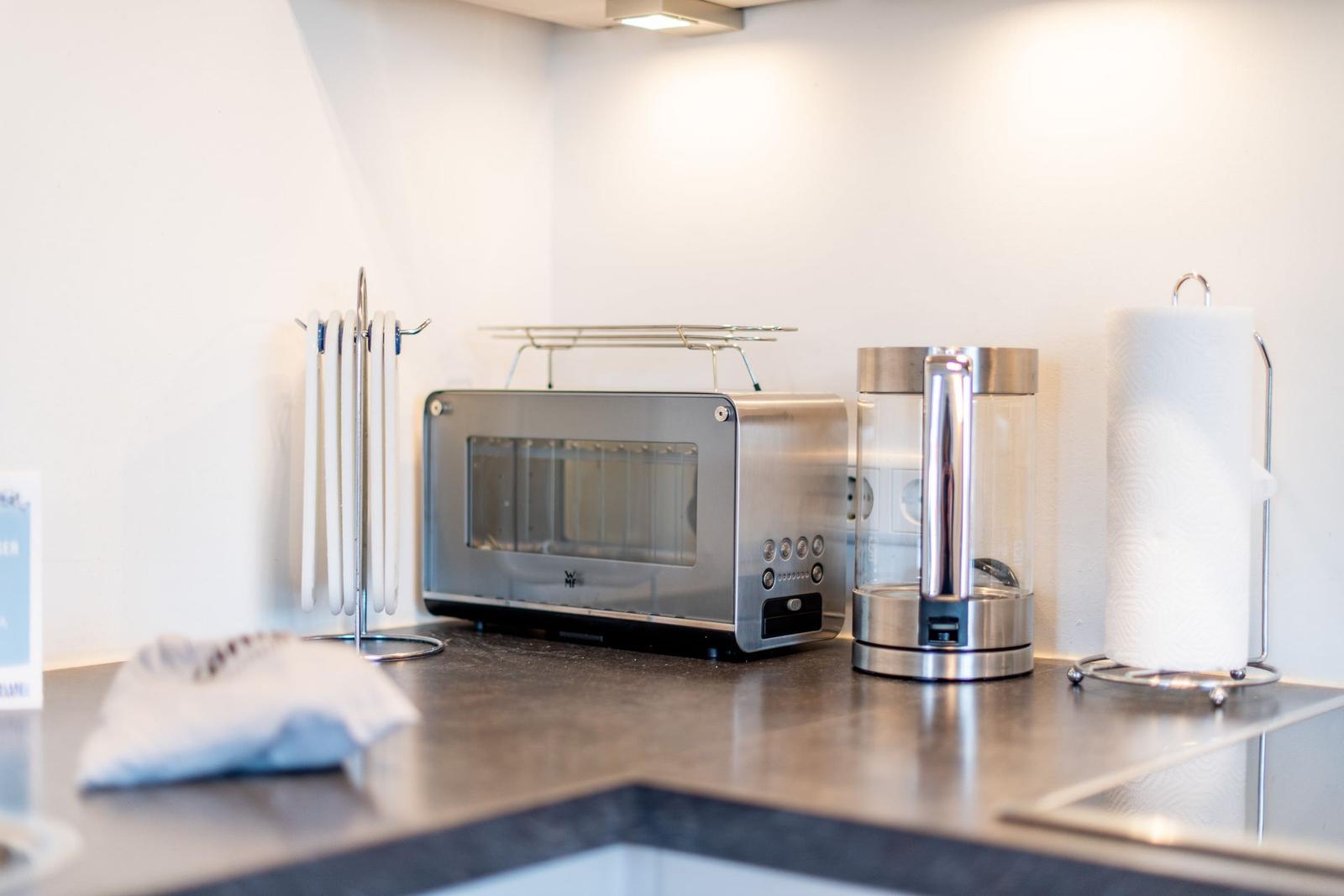 Küchenzeile mit Toaster, Wasserkocher und Papiertuchhalter.