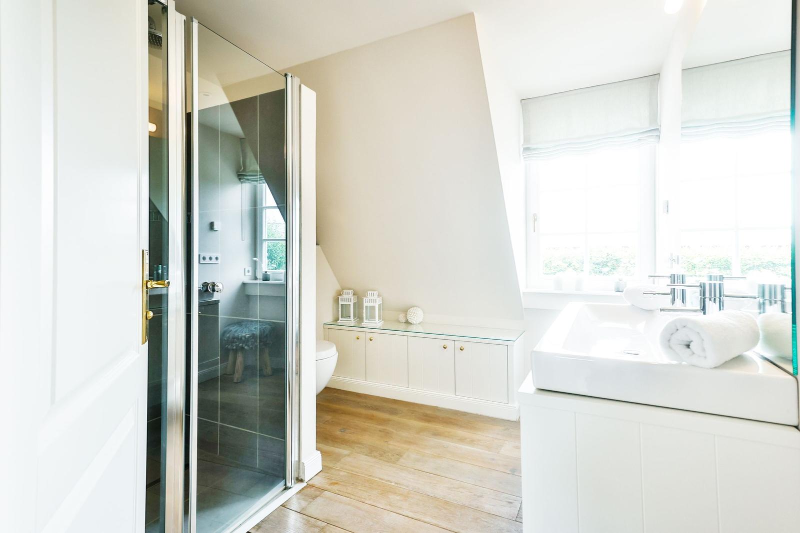 Bathroom with shower, sink, and window