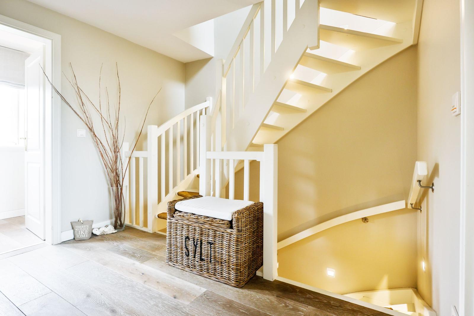 House with stairs, basket, and decor on the wall.