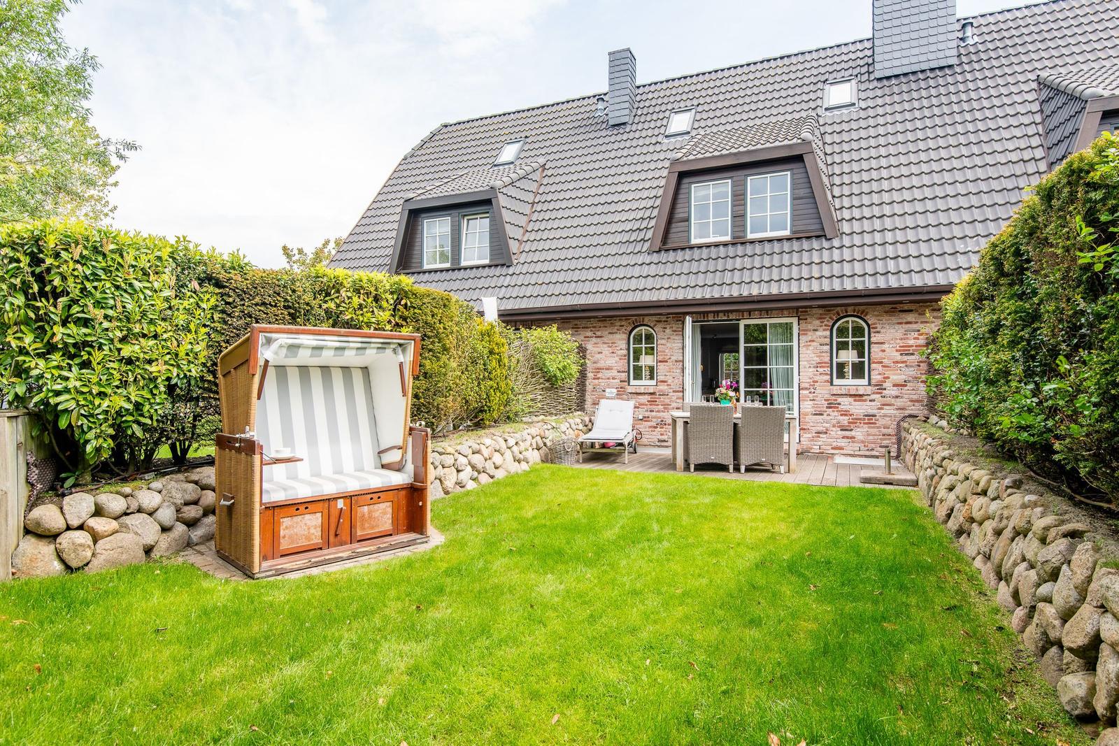 House with garden, beach chair, and terrace. Wooden terrace with garden furniture.