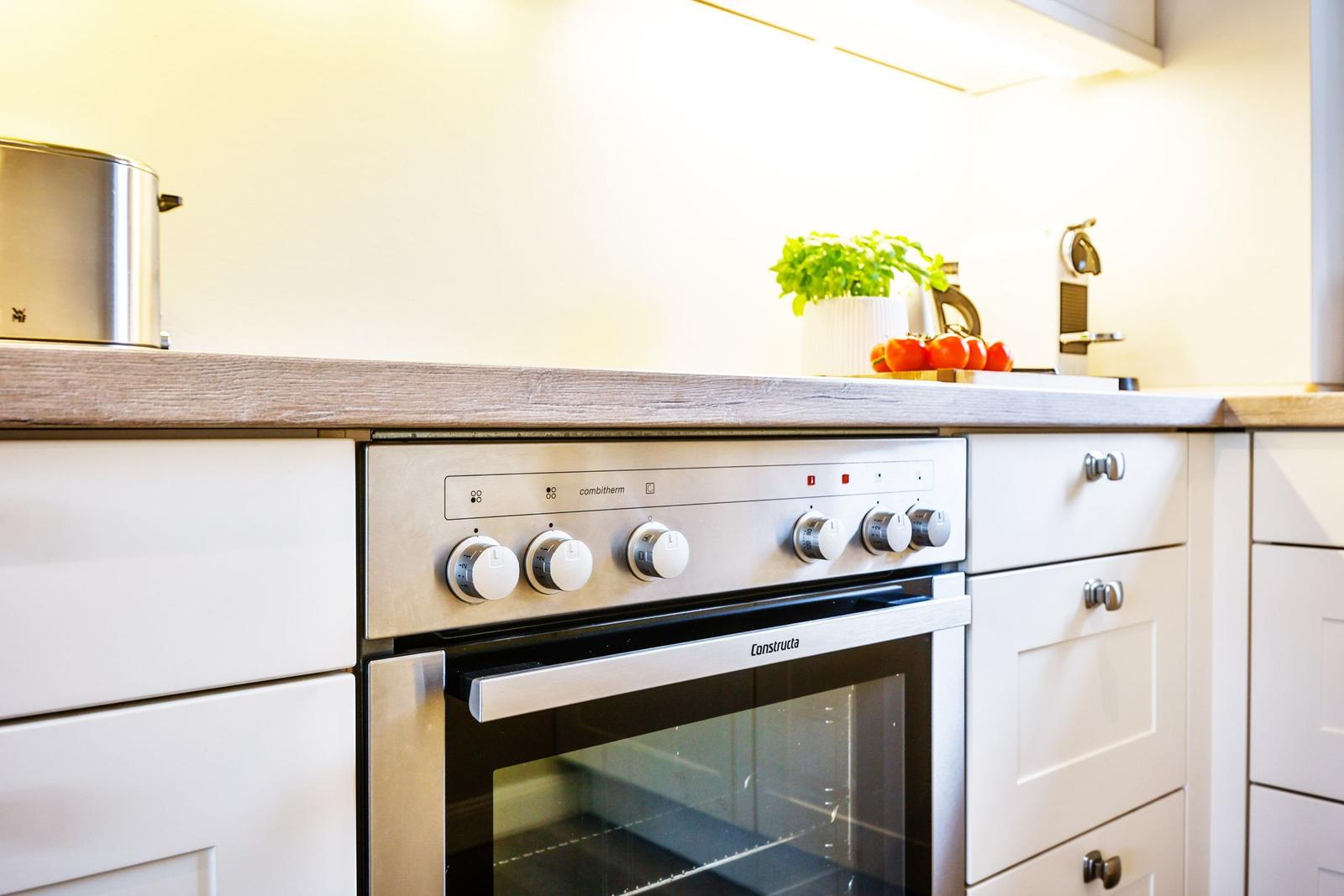 Kitchen with stainless steel stove, wooden countertop, and plants on the work surface.