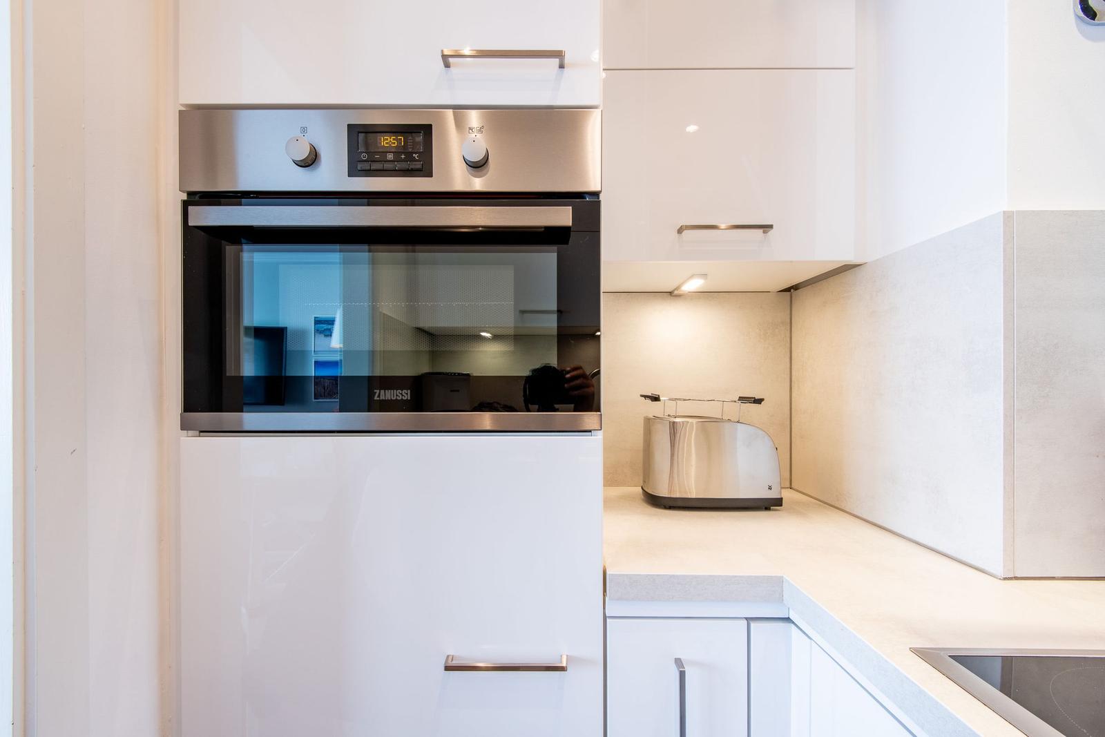 Küche mit eingebautem Ofen und Toaster auf Arbeitsplatte.