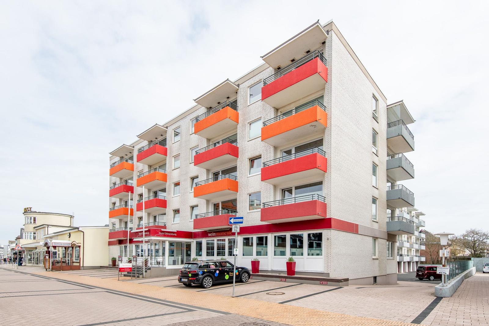 Moderne Wohnanlage mit Balkonen und Erdgeschossrestaurant.