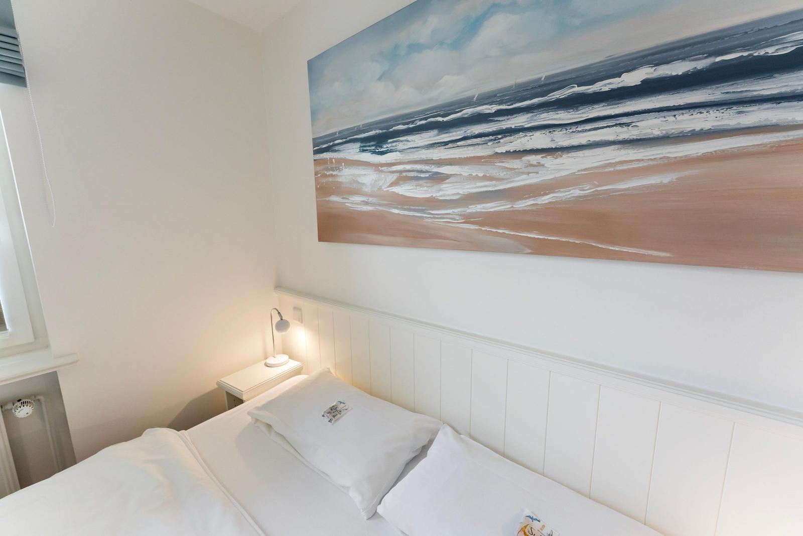 Bedroom with bed, nightstand, and wall art