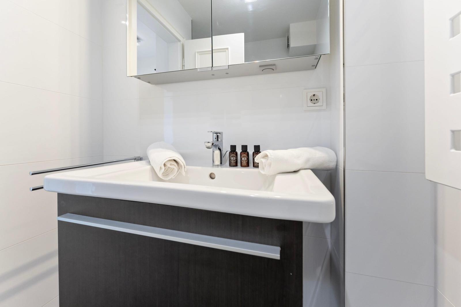 Bathroom with sink, mirror, and towels